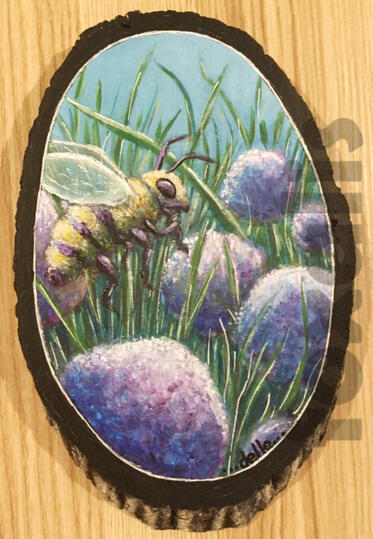 A photo of an acrylic painting on a wood slice of a bee visiting some very large purple allium flowers.